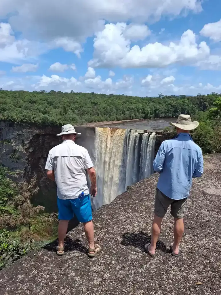 Happy tourists enjoying the view of Kaieteur Falls on a Wilderness Explorers tour.